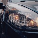 A bright LED bulb illuminates a modern projector headlight assembly with crisp white light.